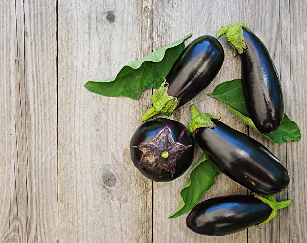 Ripe eggplants on a wooden background. Top view, flat lay.