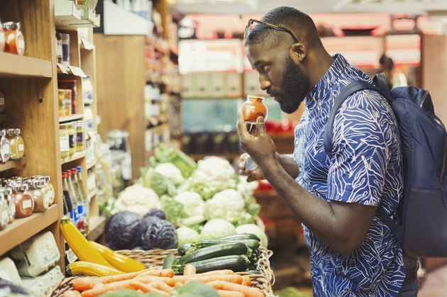 Man shopping, smelling spices in grocery store