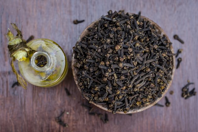 raw cloves,Syzygium aromaticum in a clay bowl with its oil beneficial for skin care and health care.