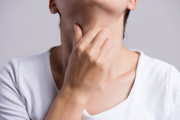 Sore Throat. Closeup Of Beautiful Young Woman Hand Touching Her Ill Neck. Healthcare and medical concept.