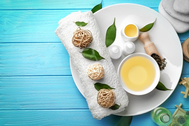 Spa composition with tea tree oil on blue wooden background