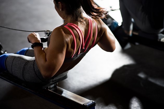 Woman working out on rowing machine, San Diego, California, USA