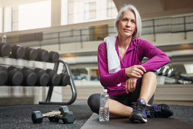 A woman over 60 losing weight by exercising at the gym