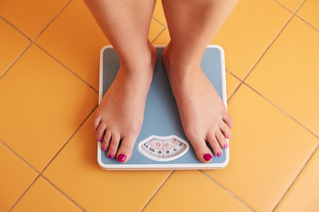 Pair of female feet on a bathroom scale