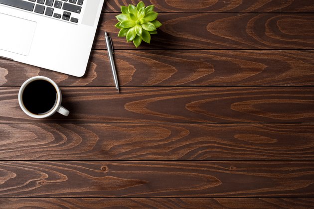 Laptop with office accessories on wooden table. Business background