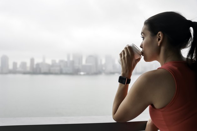 A young woman drinking coffee before a workout