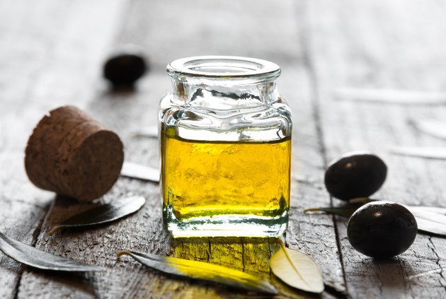 Olive oil in a glass bottle and fresh olives