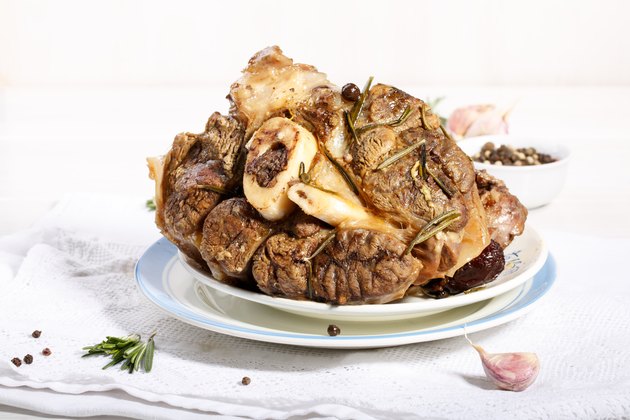 beef shanks with beef bone marrow braised with garlic rosemary and dried fruits. Rustic style.