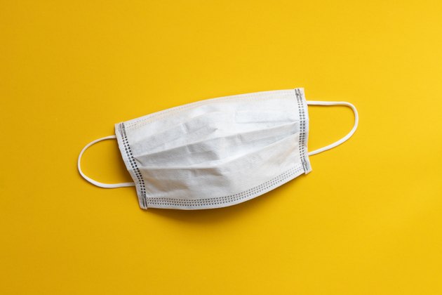 disposable face mask on yellow background
