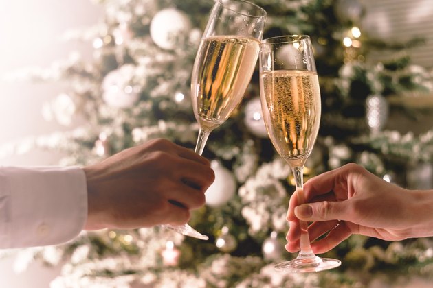 Couple holding glasses of sparkling wine for keto christmas dinner