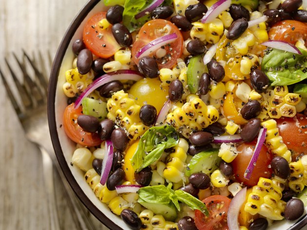 Top view of a grilled corn and black bean salad with tomatoes and onions