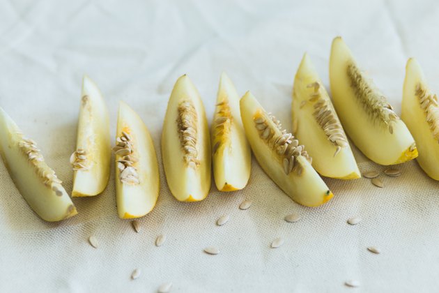 A group of brightly lit ripe melon slices.