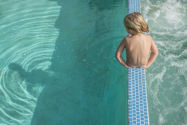 Boy sitting in between pool and hot tub