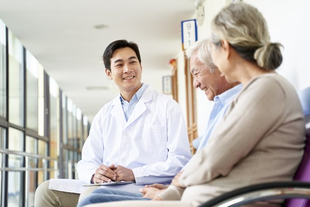 年轻的亚洲医生与年长的病人交流