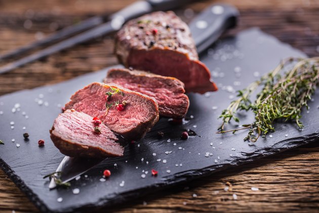 Beef Steak. Roasted Beef steak with salt pepper thyme on rustic wooden table