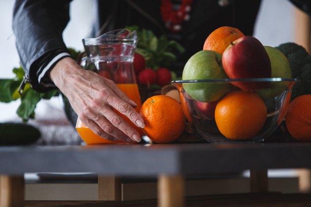 Cut out shot of a woman arranging fruits in the kitchen
