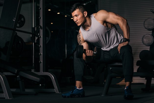 Buff Asian man doing a biceps workout at the gym