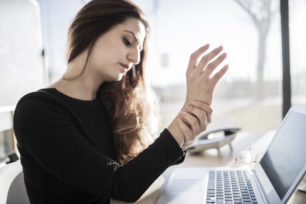 Woman working with computer and having wrist pain