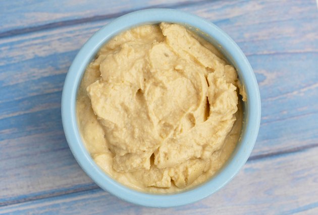 fresh hummus in a blue bowl on a blue background