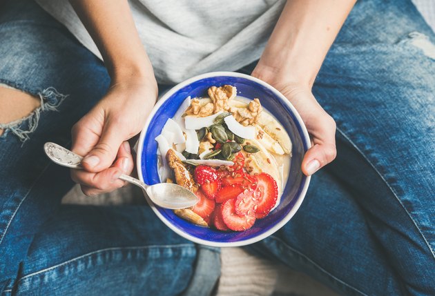 Yogurt、granola、种子、新鲜干果和碗中蜂蜜