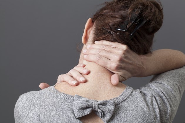 Woman rubbing the back of her neck with her hands
