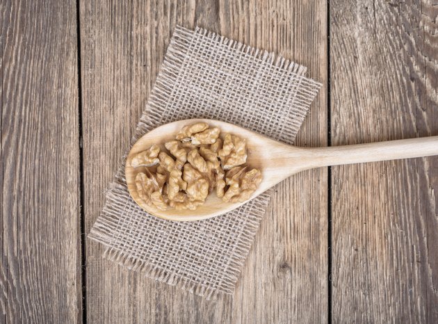 Walnuts on wooden spoon.