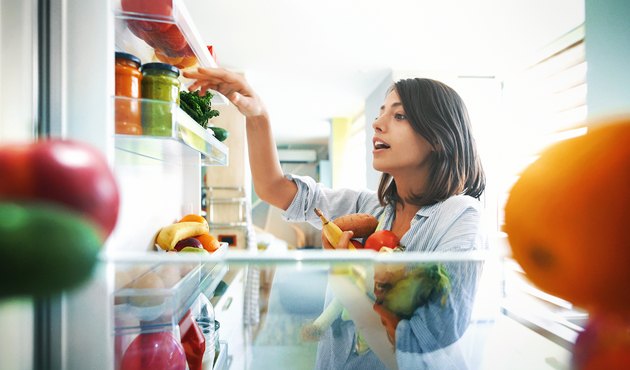女人从冰箱里拿一些水果和蔬菜