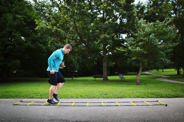 man doing agility ladder drills in the park