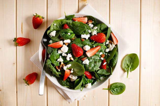 健康蔬菜沙拉的新鲜菠菜，草莓，羊乳酪和杏仁盘。