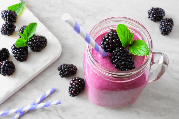 Blackberry smoothie in a mason jar, table decoration against marble