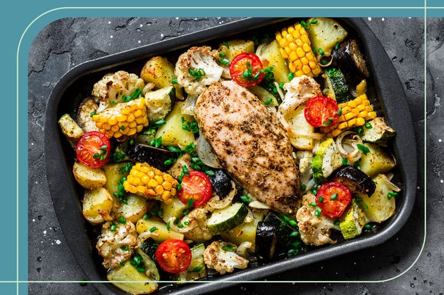 Healthy sheet-pan dinner with baked chicken breast and tomatoes, Brussels sprouts, cauliflower and corn