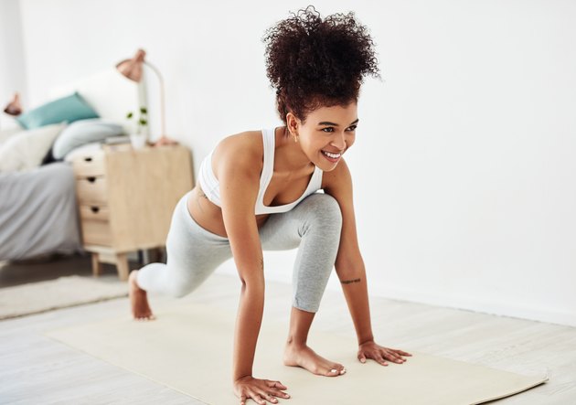 A woman with psoriasis wearing workout clothes and doing yoga at home