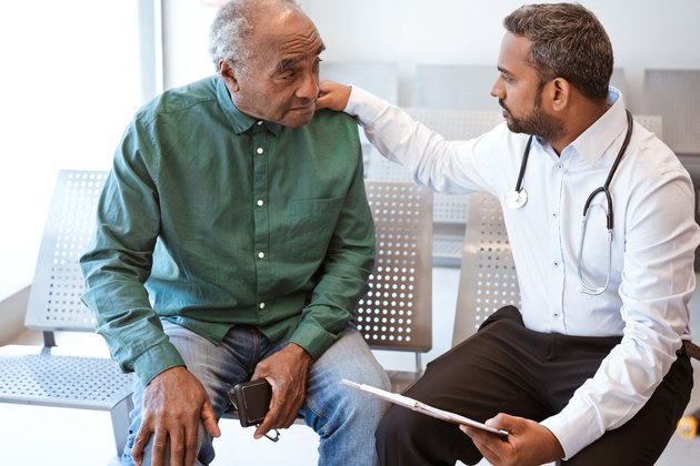 Doctor consoling sad senior male patient with prostate cancer