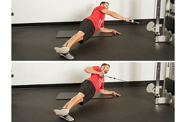 Man performing side-plank cable row on the cable machine