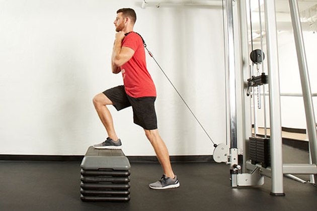 Man performing cable step-up on the cable machine
