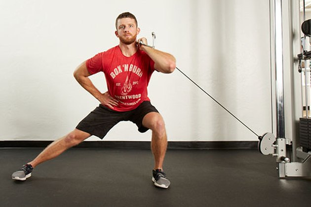 Man performing cable lateral lunge on the cable machine
