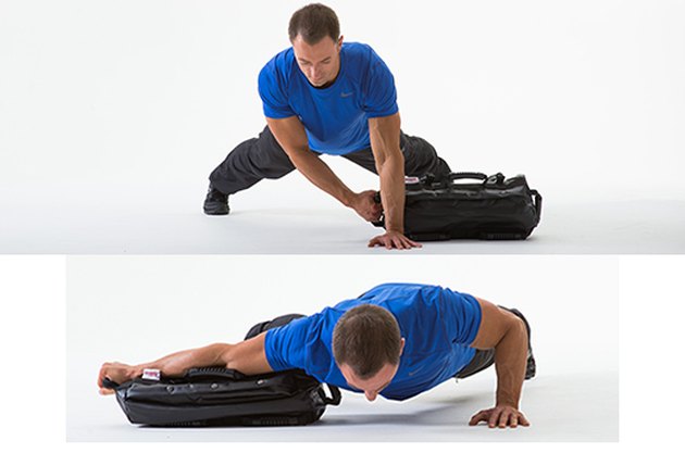Hombre haciendo un ejercicio de saco de arena lateral con saco de arena push-up