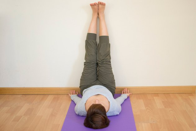 Woman demonstrating how to do Legs-Up-the-Wall pose yoga for sleep