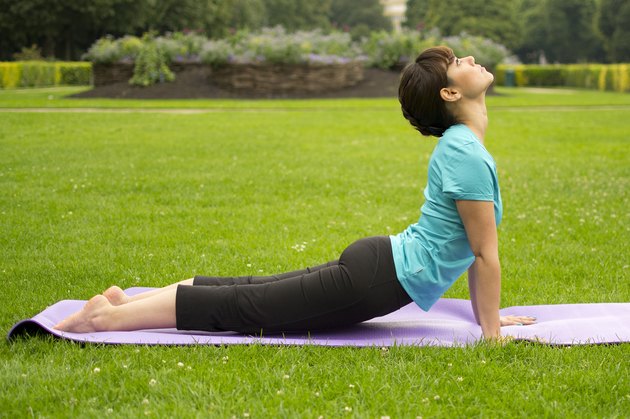 Woman demonstrating how to do the yoga pose Cobra Pose (Bhujangasana)