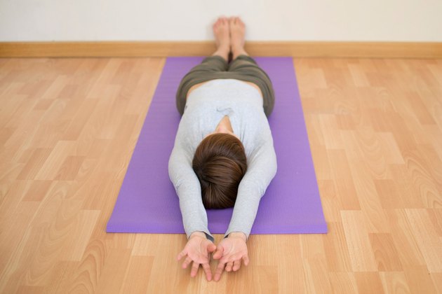 Woman demonstrating how to do Extended Corpse pose yoga for sleep