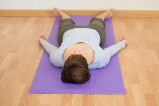 Woman demonstrating how to do Corpse pose yoga for sleep