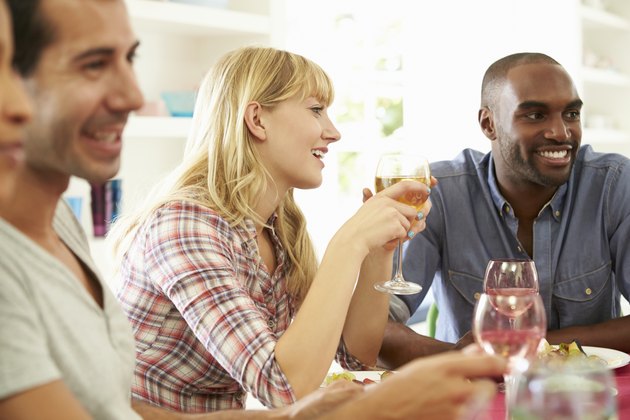 Group Of Friends Sitting Around Table Having Dinner Party