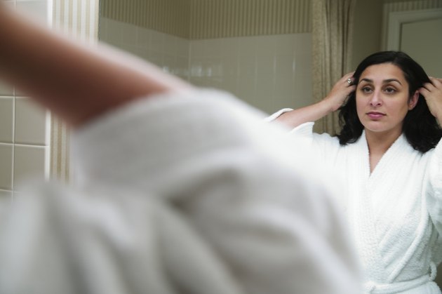 Mid adult woman standing in front of a mirror