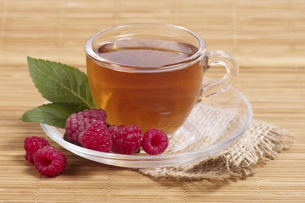 Fruit tea in cup with raspberry