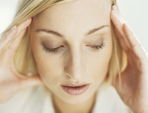 Young woman with head in hands and eyes closed,close-up