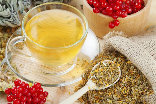cup of herbal tea, medicinal herbs and healthy berries