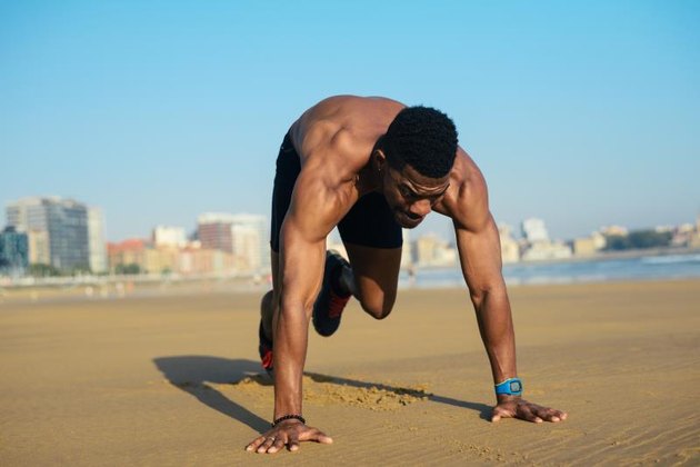 登山锻炼。适合的人在沙滩上跑前热身。对HIIT黑人运动员心肺锻炼户外。