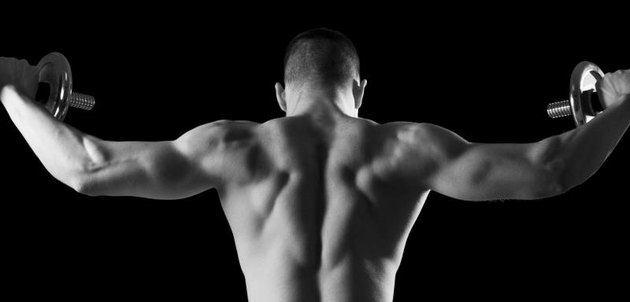 Young body builder working out and lifting weights in a gym