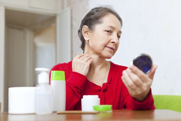 Mature woman stares on her neck
