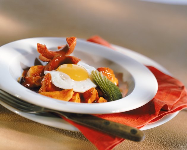Poached egg on plate with fork, close-up